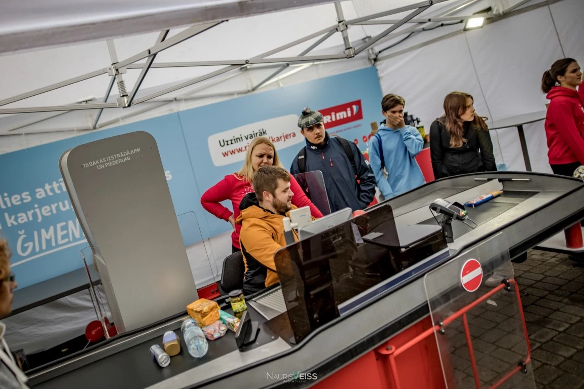 Apmeklētājs sēž pie kases aparāta Darba iespēju festivālā